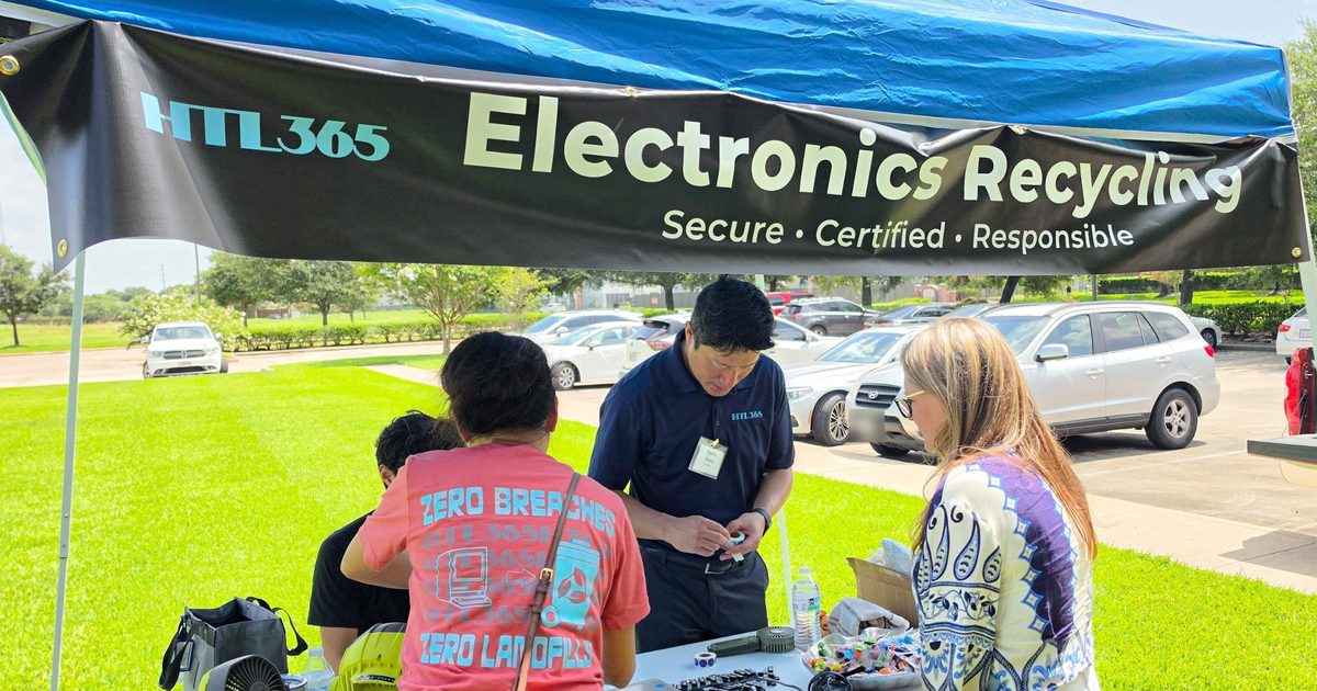 Calvin Chang in an HTL 365 polo helping residents at an HTL 365 Electronics Recycling tent