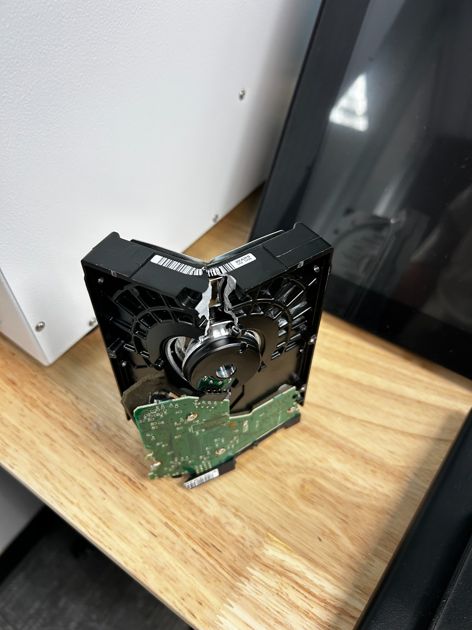 Crushed hard drive bent 90 degrees after secure data destruction at HTL 365 Houston TX
